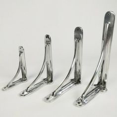 three silver metal brackets on a white background