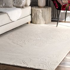 a living room with a white rug on the floor next to a couch and chair