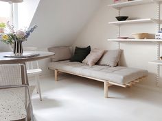 a white room with a couch, table and shelves