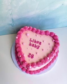 a heart shaped birthday cake with pink frosting