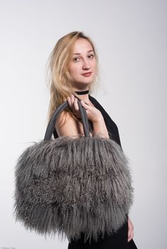 Handcrafted statement bag made of genuine Tibetan lambs wool.  The fur is lustrous and luxuriously soft with defined curls. Each bag is unique in character and feel, truly one of a kind, just like ... you! The unique thing about this bag is that you can wear it 3 different ways, for every occasion! On Your Arm: The comfortable suede handles allow you to wear your bag on your arm for a business chic look. On Your shoulder: Running errands, need both arms?  Your PEBBLE bag comes with a removable long chain that allows you to wear your bag on your shoulder or cross-body. For a more casual look, easily tuck in the handles and enjoy the freedom! Oh Clutch! Going to a formal event? Tuck in the handles, wrap the chain around your wrist for an added touch of glamour and voila.. you have a sleek cl Business Chic, Fur Bag, Statement Bag, Defined Curls, Bag Luxury, Nov 2, Unique Things, Long Chain, Chic Look