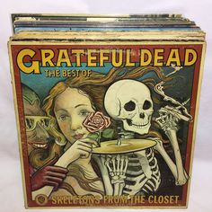 a box with a skeleton holding a rose in it's hand and another skull on the other side