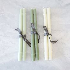 three green candles tied with ribbon on white background