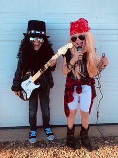 two people are dressed up as rockers and one is holding a guitar