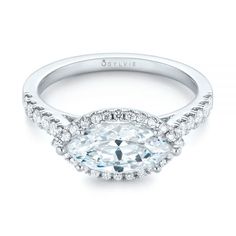 an oval cut diamond engagement ring with halos on the band and side stones in white gold