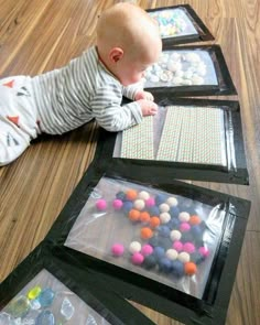 a baby laying on the floor next to some bags filled with balls and plastic wrappers