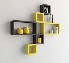 yellow and black shelves on the wall with cups, mugs and utensils