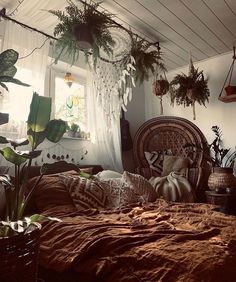 a bedroom with plants hanging from the ceiling and a bed in front of a window