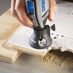 a person using a drill to cut wood