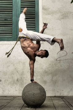 a man doing a handstand on top of a ball