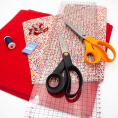 scissors, tape, and other crafting supplies are laid out on a piece of fabric