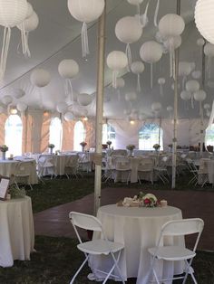 the inside of a tent with tables and chairs set up for a wedding or other function