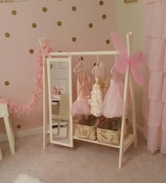 a pink and gold girls'bedroom with polka dots on the wall, white furniture and accessories