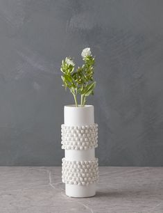 a white vase with some flowers in it