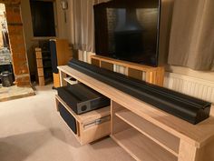 a flat screen tv sitting on top of a wooden shelf in front of a fireplace