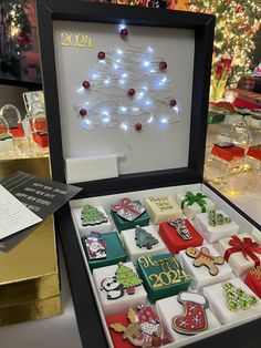 a christmas tree made out of cookies in a box with lights on the top and decorations around it