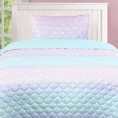 a bed with a blue and pink bedspread