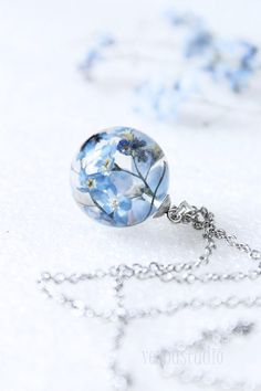 "Delivery of orders is carried out as usual. All orders are being sent using our warehouse in the United States via USPS. Transparent resin orb necklace with real blue Forget me not flowers. Our jewelry is created using real, hand-collected plants of wild nature of Carpathian Mountains. ✿... The pendant in sizes: 25 mm in diameter the size of chain may vary... ... Pressed Forget me not flowers, crystal eco resin, hypoallergenic stainless steel chain... ... Forget-Me-Not plants symbolize true lov Blue Forget Me Not Flowers, Sphere Necklace, Orb Necklace, Forest Jewelry, Real Flower Necklace, Carpathian Mountains, Spring Bracelet, Nature Necklace, Magical Jewelry