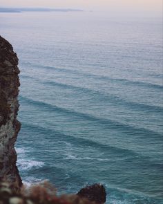 an ocean view with waves coming in from the cliff