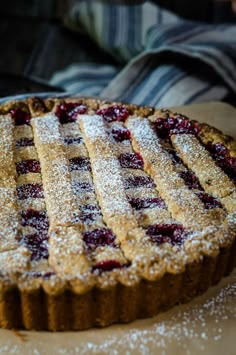 a pie is covered in powdered sugar and sits on a table