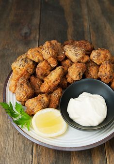 a white plate topped with tater tots next to a bowl of ranch dressing