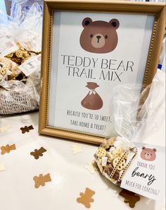 there is a teddy bear trail mix sign next to some cookies and crackers on the table