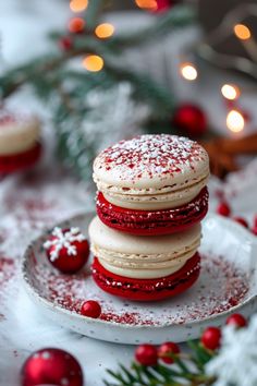 Festive macarons stacked on a plate, dusted with powdered sugar, surrounded by holiday decorations. Christmas Desserts Pastry, Christmas Flavor Macarons, Macaroons Recipe Christmas, Cranberry Orange Macarons, Christmas Maccarone Recipes, Unique Christmas Baking, Sugar Cookie Macarons, Christmas Flavors Desserts, Macroonies Recipe Flavors