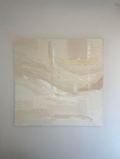 an abstract painting hangs on the wall above a bed in a room with white walls