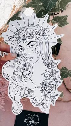 a woman with flowers on her head holding onto a paper cutout that says,