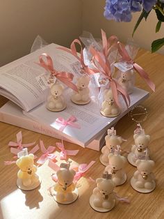 small teddy bears sitting on top of a table next to an open book