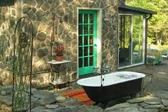 a bath tub sitting in front of a stone building