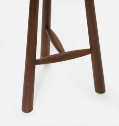 a wooden stool that is made out of wood and has an upholstered seat