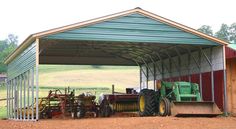 a tractor is parked in front of a metal building with a green cover over it