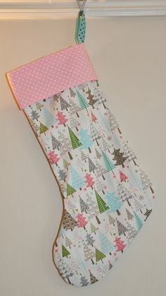 a christmas stocking hanging on the wall with polka dot trimmings and trees