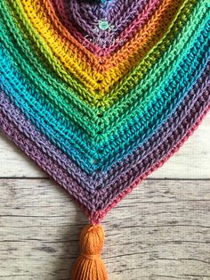 a multicolored crocheted triangle with a tassel