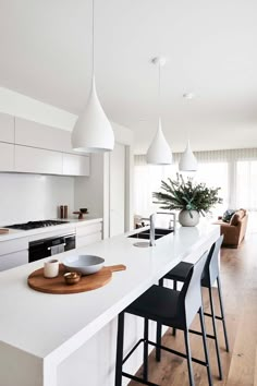 a kitchen with white counter tops and black chairs