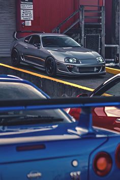 several cars parked in front of a red building