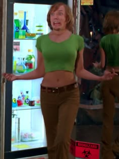 a woman standing in front of a refrigerator with her hands on her hips and mouth wide open