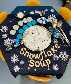 a table with snowflake soup and spoons on it, surrounded by other items