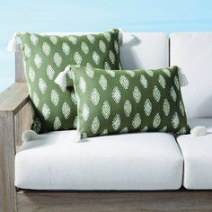 two green and white pillows sitting on top of a couch