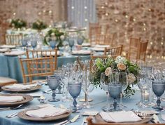 the table is set with blue linens and silverware for an elegant wedding reception