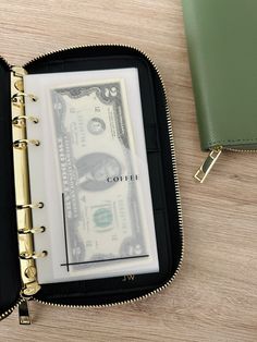 a wallet with money in it sitting on top of a table next to a purse