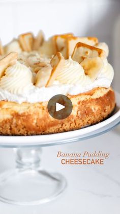 banana puddinging cheesecake on a cake plate with whipped cream and sliced bananas in the middle