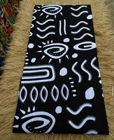 a black and white rug with an abstract design on the floor next to other items