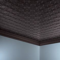 an empty room with blue walls and ceiling tiles