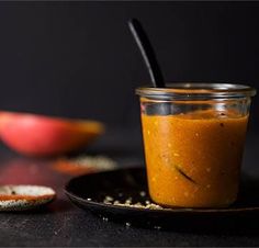 a glass jar filled with food sitting on top of a black plate