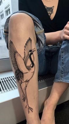 a woman with a bird tattoo on her leg