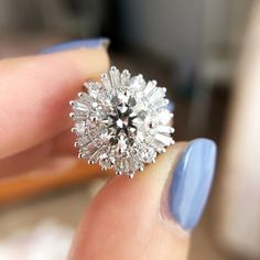 a close up of a person holding a ring with diamonds on it's finger