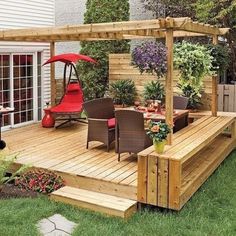 a wooden deck with chairs and an umbrella on it next to a patio covered in plants