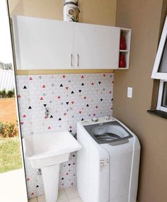 a washer and dryer sitting in a small room next to a window with an open door